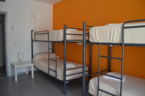 Arroyo de la LuzHostel Divino Morales的橙色墙壁的客房内设有两张双层床。