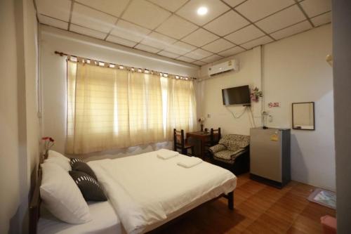 曼谷OYO 75440 Nara Hostel的小房间设有一张床和一把椅子