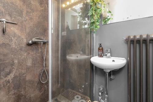 雷克雅未克Venture Vacation - Cozy and Central Apartment的带淋浴、水槽和镜子的浴室