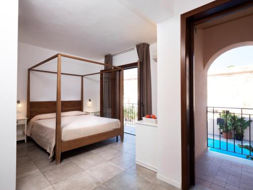 兰佩杜萨Moresco Resort的一间卧室设有一张天蓬床和一个阳台