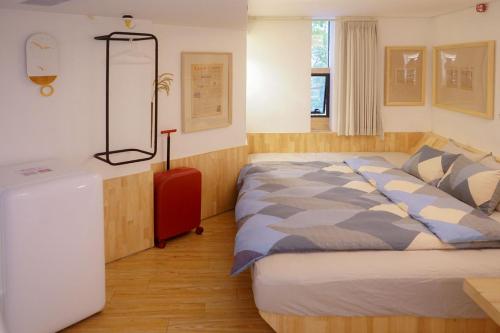 广州同古舍博物馆酒店的一间卧室配有一张大床和一个红色梳妆台
