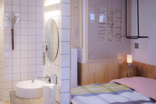 广州同古舍博物馆酒店的一间带水槽、床和镜子的浴室