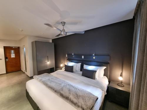 开普敦大西洋事理精品酒店的一间卧室设有一张大床和黑色墙壁