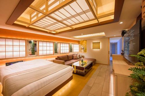 东京Hotel P'sResort Adults only 大人専用的一间带大床的卧室和一间客厅