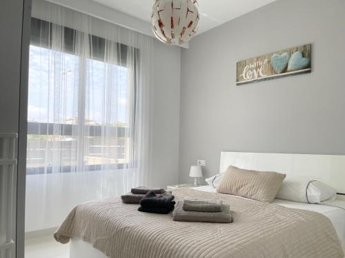 皮拉尔－德拉奥拉达达Apartment Playa Elisa Bay的白色卧室,配有带毛巾的床