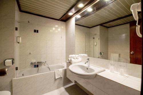 贝尔格莱德朱果斯拉维亚加尔尼酒店的浴室配有盥洗盆、浴缸和盥洗盆