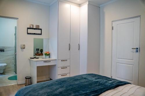 约翰内斯堡3 on Tessa Guesthouse的一间卧室配有床、水槽和镜子