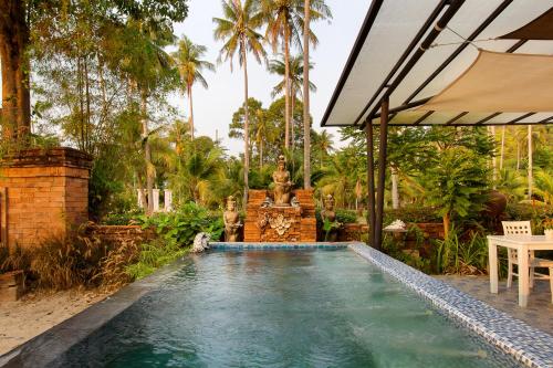 象岛The White Knot Koh Chang的花园内的游泳池,花园内设有喷泉
