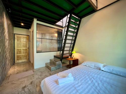 怡保DoSomething Guest House 2的一间卧室设有一张床和一个螺旋楼梯