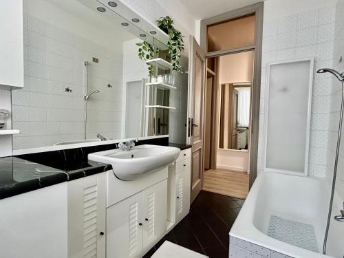 克雷马D-Place Apartment Piazza Duomo Crema的白色的浴室设有水槽和浴缸。