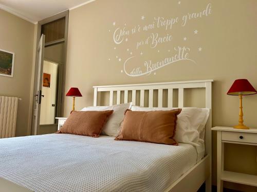 克雷马D-Place Apartment Piazza Duomo Crema的一间卧室配有一张铺有白色床单的床,墙上挂着文字。