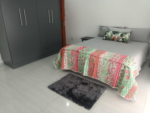 KingsboroughLotus Accommodation的一间卧室配有一张带毯子和地毯的床