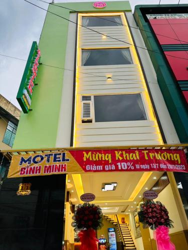 波来古市Bình Minh Motel的带有木偶小 ⁇ 的卡兹密密密的翻转标志的建筑