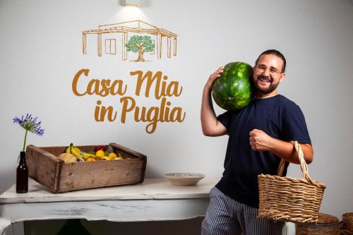 孔韦尔萨诺Casa mia in Puglia的一个拿着西瓜和一盒水果的人