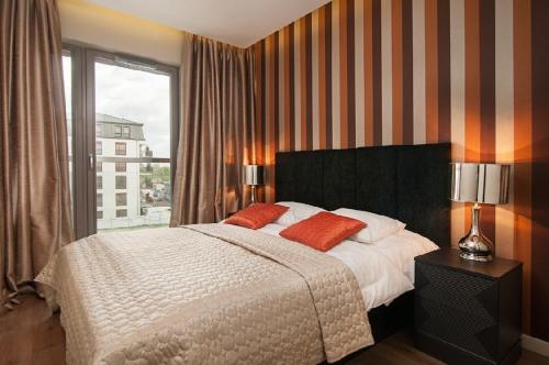 格但斯克沃特兰阿帕蒂佛公寓酒店的一间卧室设有一张大床和一个窗户。