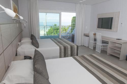 瓜鲁雅维奇诺阿尔玛乐酒店的酒店客房设有两张床、一张书桌和一个窗户。