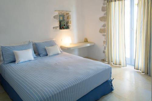 圣玛丽亚Kalma villa的一间卧室配有一张蓝色和白色条纹的床