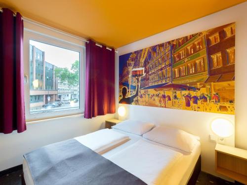 杜塞尔多夫杜塞尔多夫市住宿加早餐旅馆的卧室配有一张床,墙上挂有绘画作品