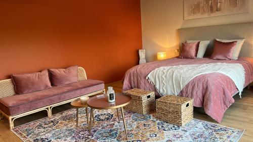 SolesmesSol'm Lodges的一间卧室配有一张床、一张沙发和一张桌子