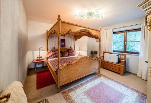 米滕瓦尔德Romantische 5-Sterne- Ferienwohnungen的一间卧室设有天蓬床和窗户。