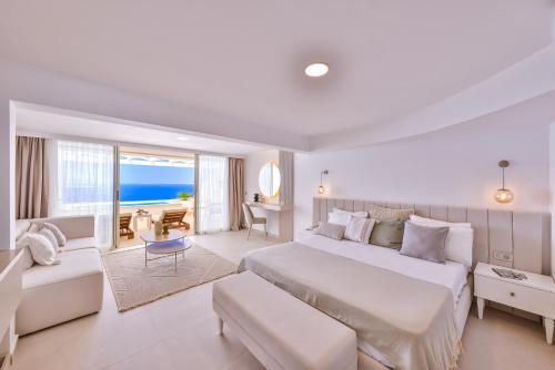 卡斯拉库姆萨尔酒店的一间白色的卧室,配有一张大床,一间享有海景的房间