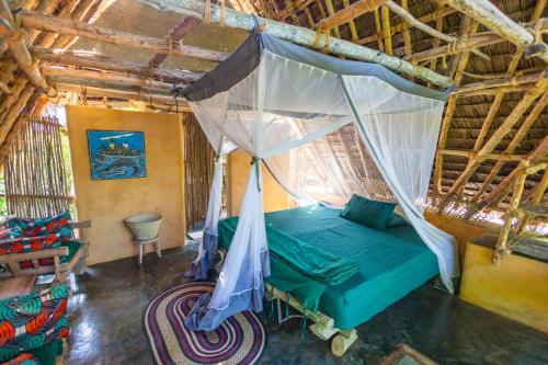 Mbweni琼碧岛珊瑚礁公园度假村的一间卧室配有一张带蚊帐的床