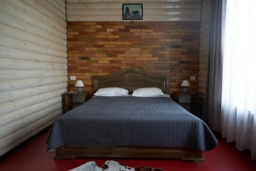 卡拉科尔阿尔戈旅馆的一间卧室设有一张床和砖墙