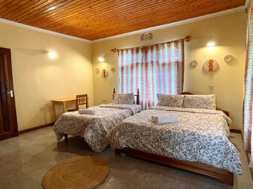 阿鲁沙Toiwo Residence Arusha的一间卧室设有两张床和窗户。