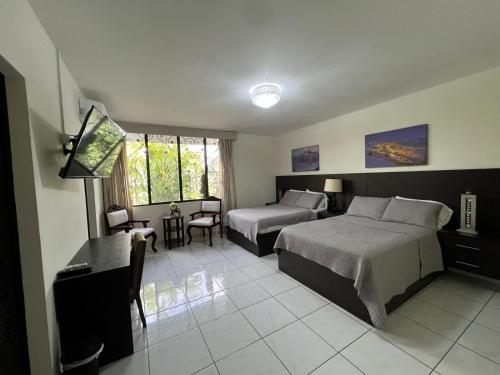 圣萨尔瓦多Hotel Casa Pamplona的酒店客房带两张床和一张桌子以及椅子。