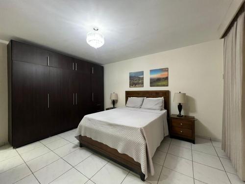 圣萨尔瓦多Hotel Casa Pamplona的一间卧室设有一张大床和一个床头柜。