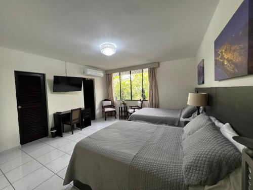 圣萨尔瓦多Hotel Casa Pamplona的酒店客房设有两张床和一张桌子。