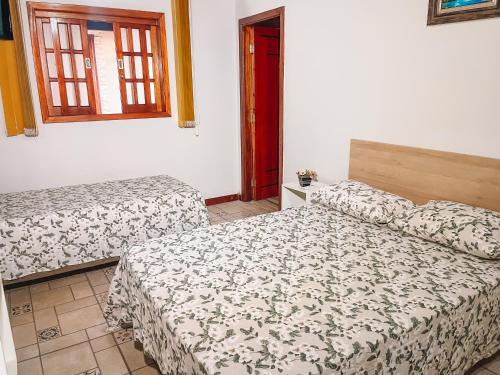 瓜佩Pousada Estância Mineira的一间卧室设有两张床和窗户。