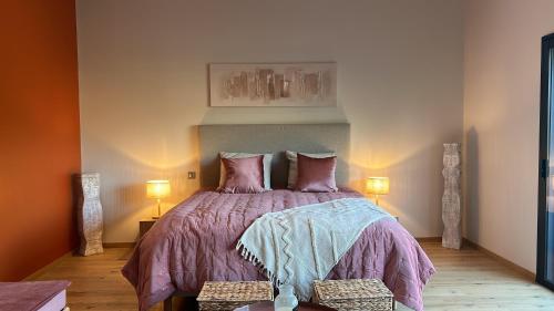 SolesmesSol'm Lodges的一间卧室配有一张带紫色棉被的床和两盏灯。