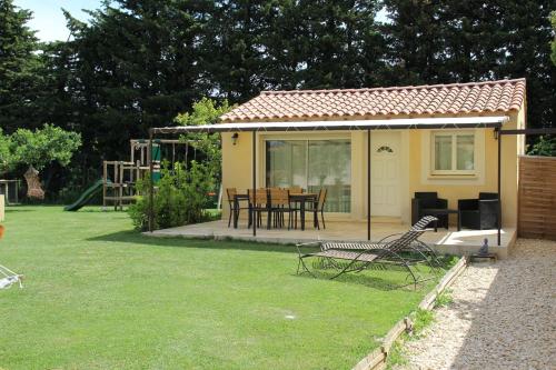 萨尔里昂红磨坊度假屋的院子中带桌椅的黄色小房子