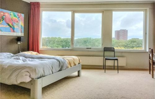 弗利辛恩3 Bedroom Stunning Home In Vlissingen的一间卧室设有一张床、一个窗口和一把椅子