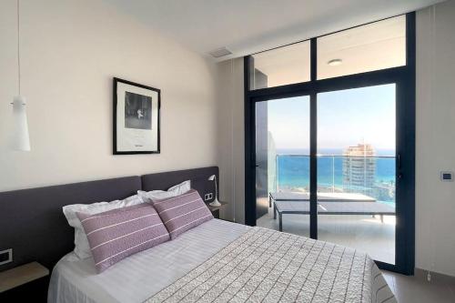 贝尼多姆Luxury apartment Residencial Sunset Drive - Benidorm, España的一间卧室设有一张床,享有海景