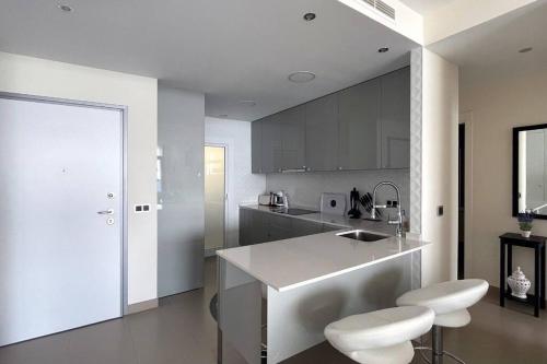 贝尼多姆Luxury apartment Residencial Sunset Drive - Benidorm, España的厨房配有柜台和2张凳子