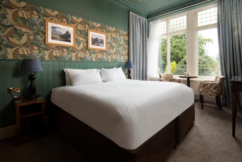 安布尔塞德Lakehouse at The Waterhead Inn的卧室设有一张白色大床和一扇窗户。