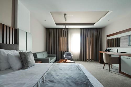 普里什蒂纳普里什蒂纳酒店的酒店客房设有一张大床和一张书桌。