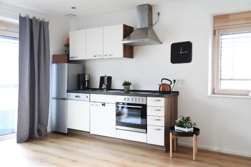 哈尔堡Appartement Burgblick的厨房配有白色橱柜和炉灶烤箱。