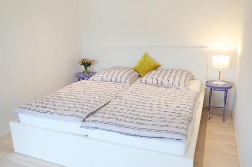 哈尔堡Appartement Burgblick的一张带两个枕头和两张桌子的白色床