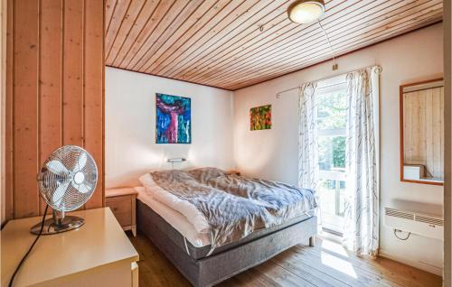 比戈Beautiful Home In Vig With 4 Bedrooms, Sauna And Wifi的一间卧室设有一张床、一个窗口和风扇