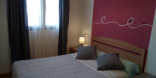 巴尔德利纳雷斯Apartamento Valdesquí的一间卧室配有一张粉红色墙壁的床