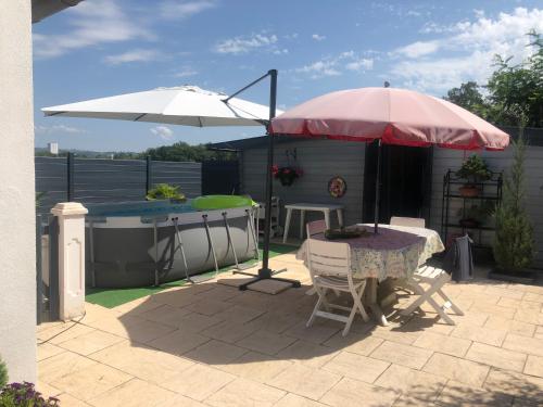 阿列河畔美岸MAISON DES LILAS的一个带桌子和遮阳伞的庭院