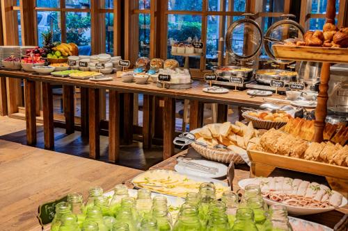 波哥大佰欧舒丽GHL酒店的餐桌上的自助餐,包括面包和糕点