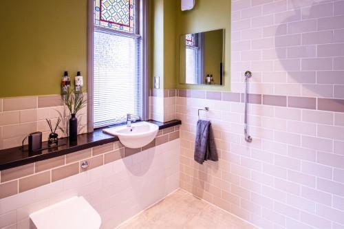 约维尔Eton House - Self Check-In Serviced Studios & Rooms的一间带水槽和卫生间的浴室以及窗户。