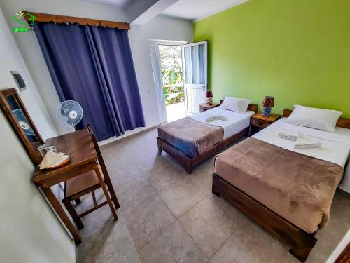 Ribeira GrandePousada Green Place的酒店客房设有两张床和窗户。