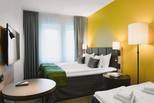 哈宁厄哈宁厄温迪品质酒店的酒店客房设有一张大床和一张桌子。