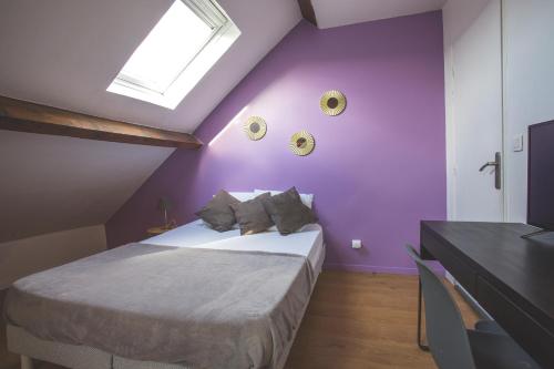 图尔昆Colocation de luxe à Tourcoing avec jardin的一间卧室设有紫色墙壁和一张床