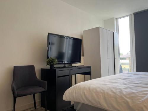 埃因霍温Room 101 - Eindhoven的一间卧室配有电视,床边设有椅子